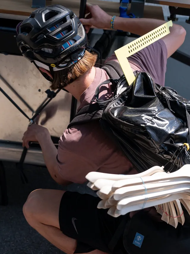 Velofahrer mit Helm trägt Siebdruckrahmen
